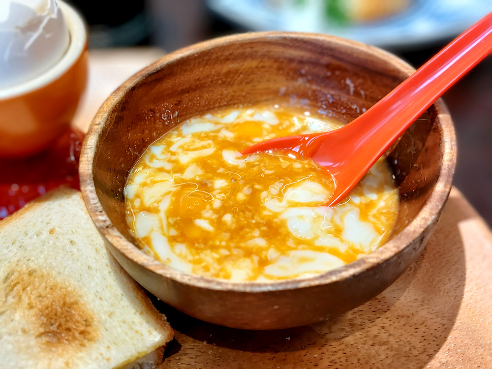渋谷にオープンしたシンガポール料理店「SINKIES（シンキーズ）」のカヤトーストは温泉卵をディップします